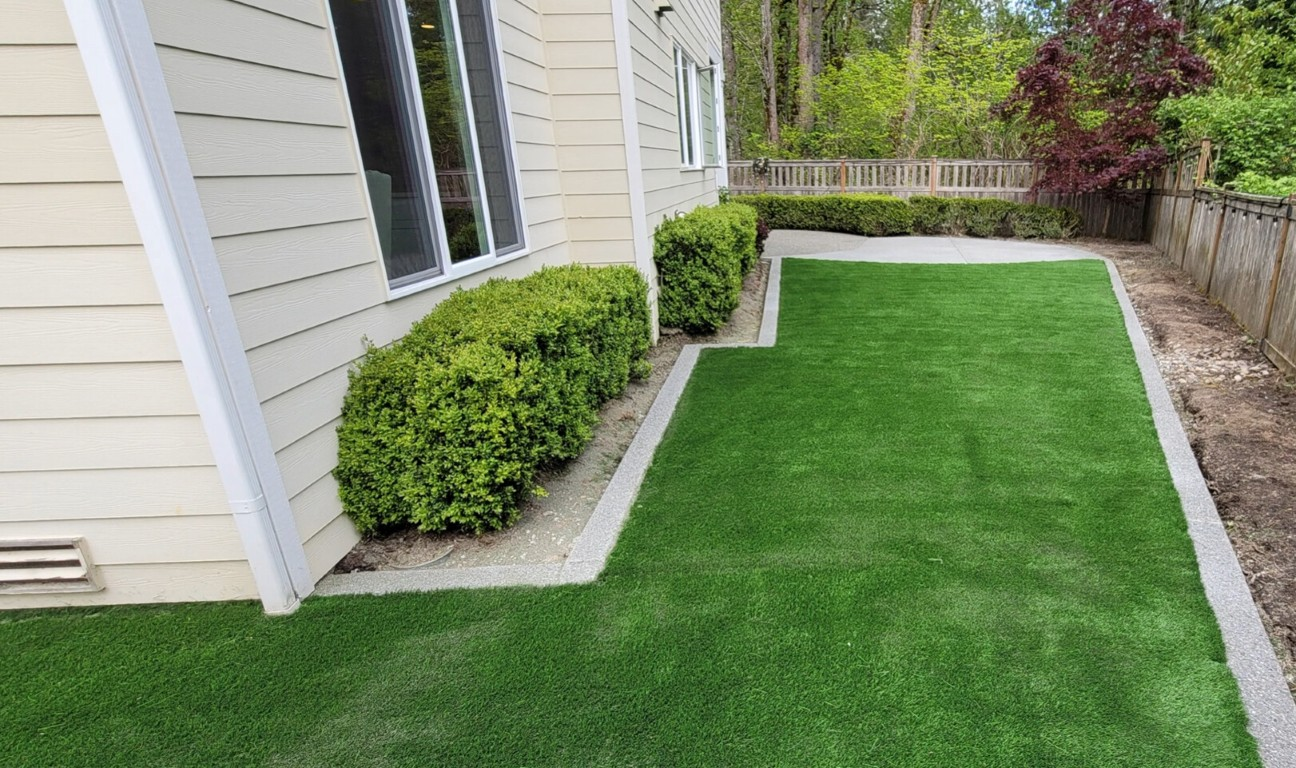 Side yard artificial turf with trimmed hedges