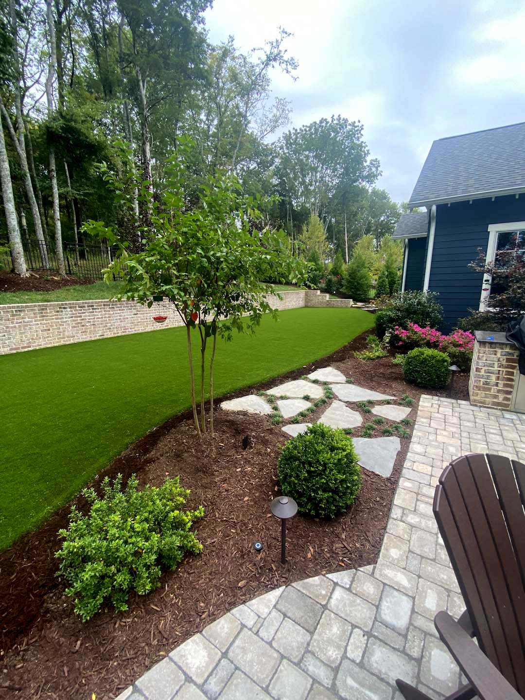 Backyard retreat with turf, stone path and paver patio