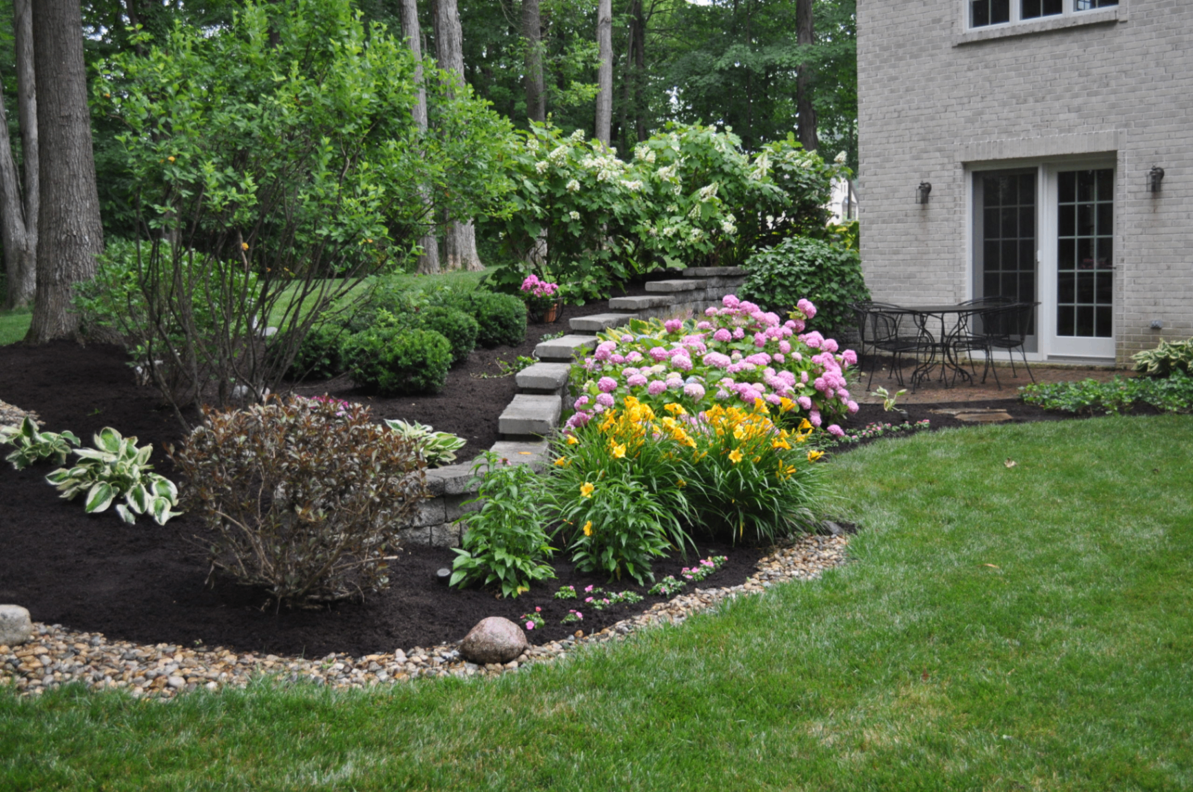Landscaped bed with hydrangeas, daylilies and stone steps